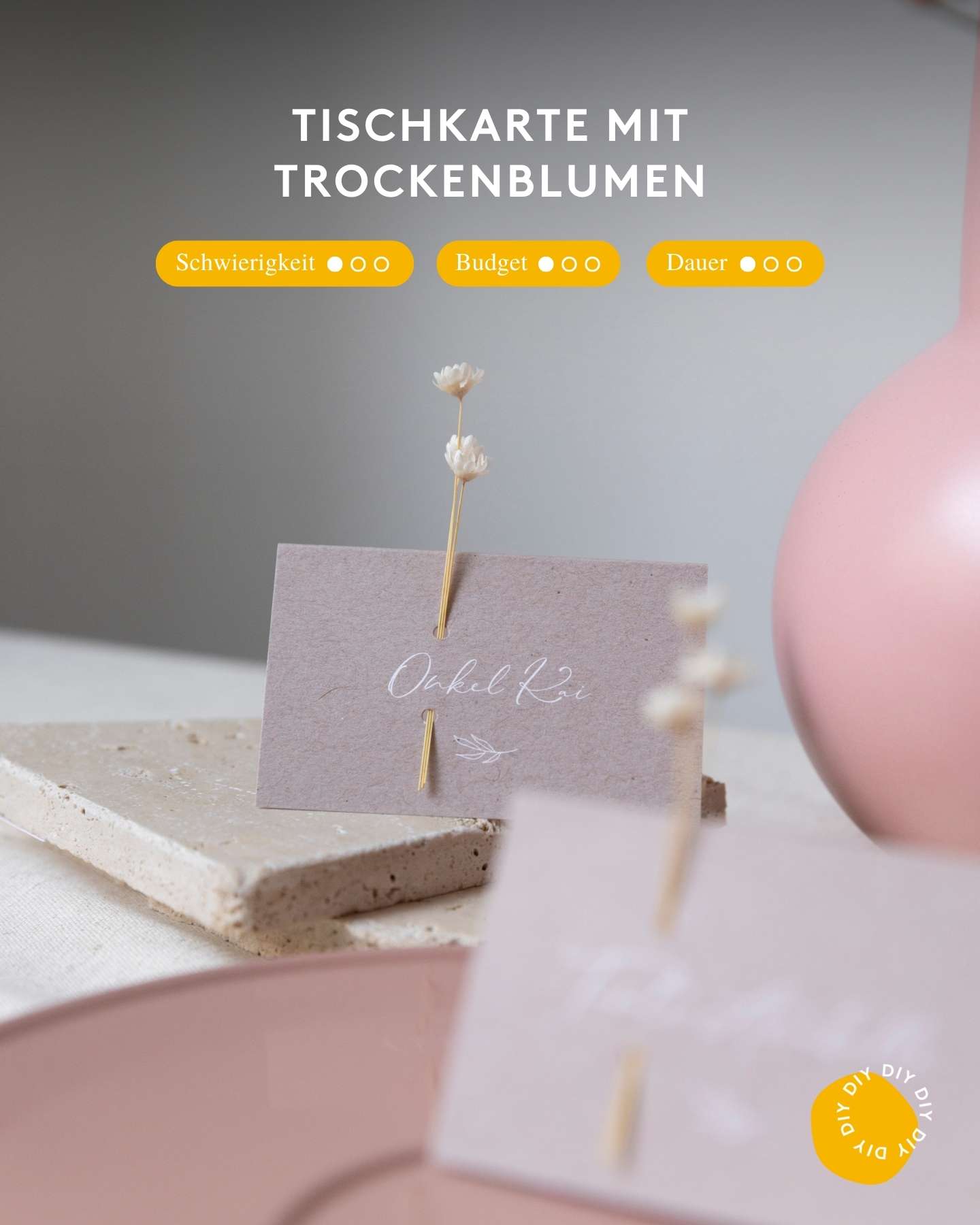 Eine Tischkarte mit Namen wird mit einer Trockenblume verziert als DIY zur Taufe