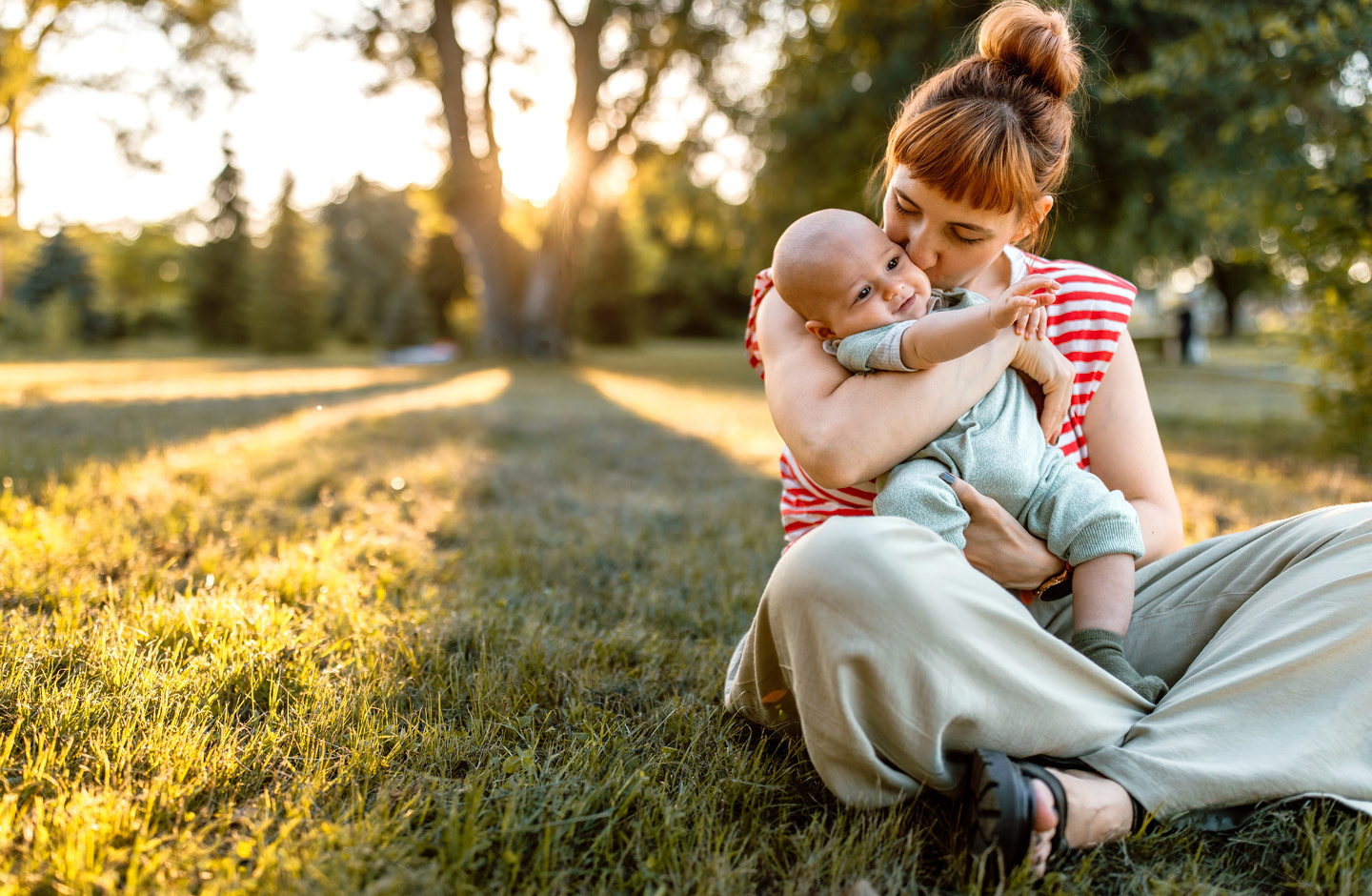 Eine Mutter genießt mit ihrem Baby Zeit in einem Parkr im Sommer